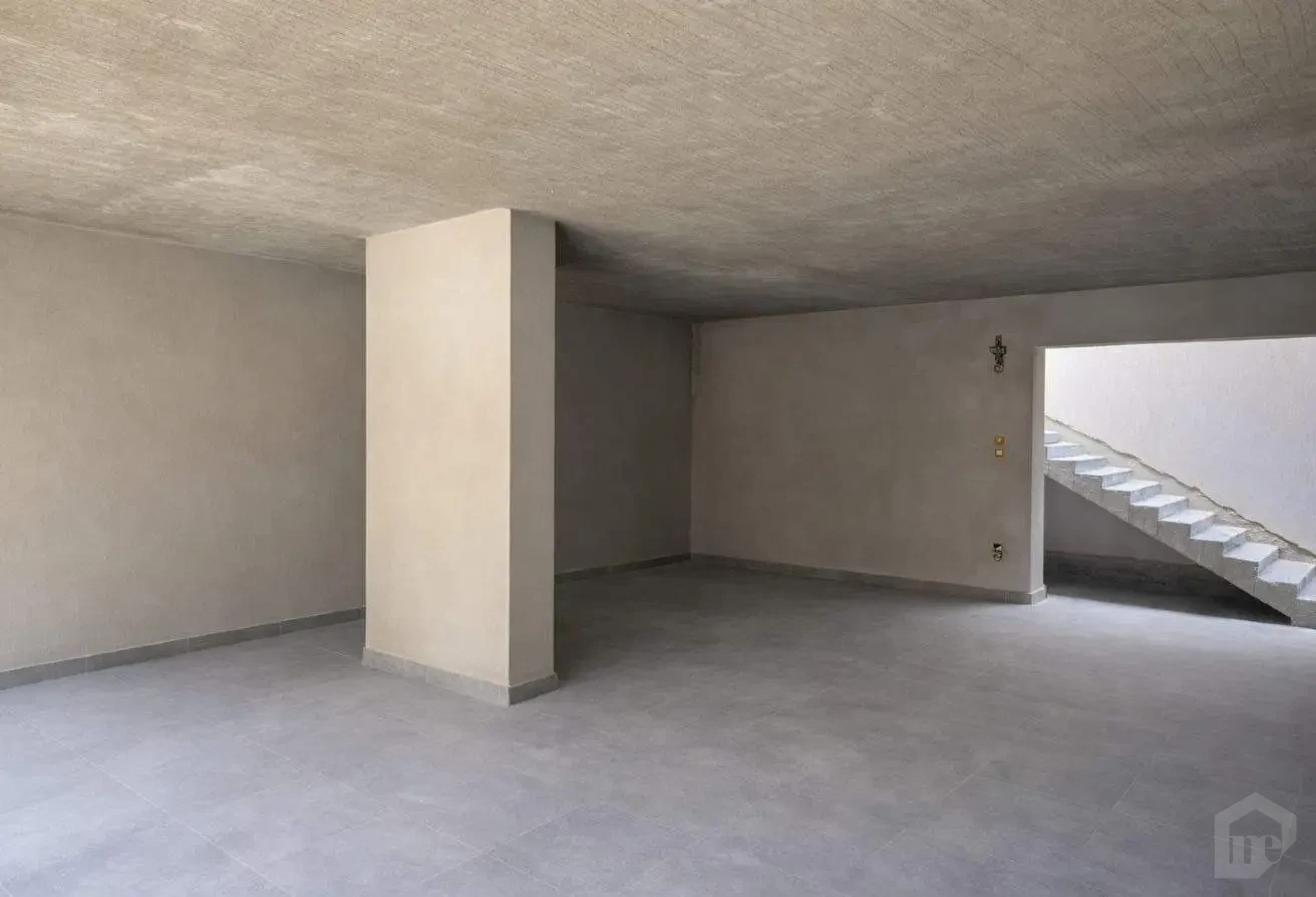 Spacious Basement Interior with Partial Tiling and Staircase