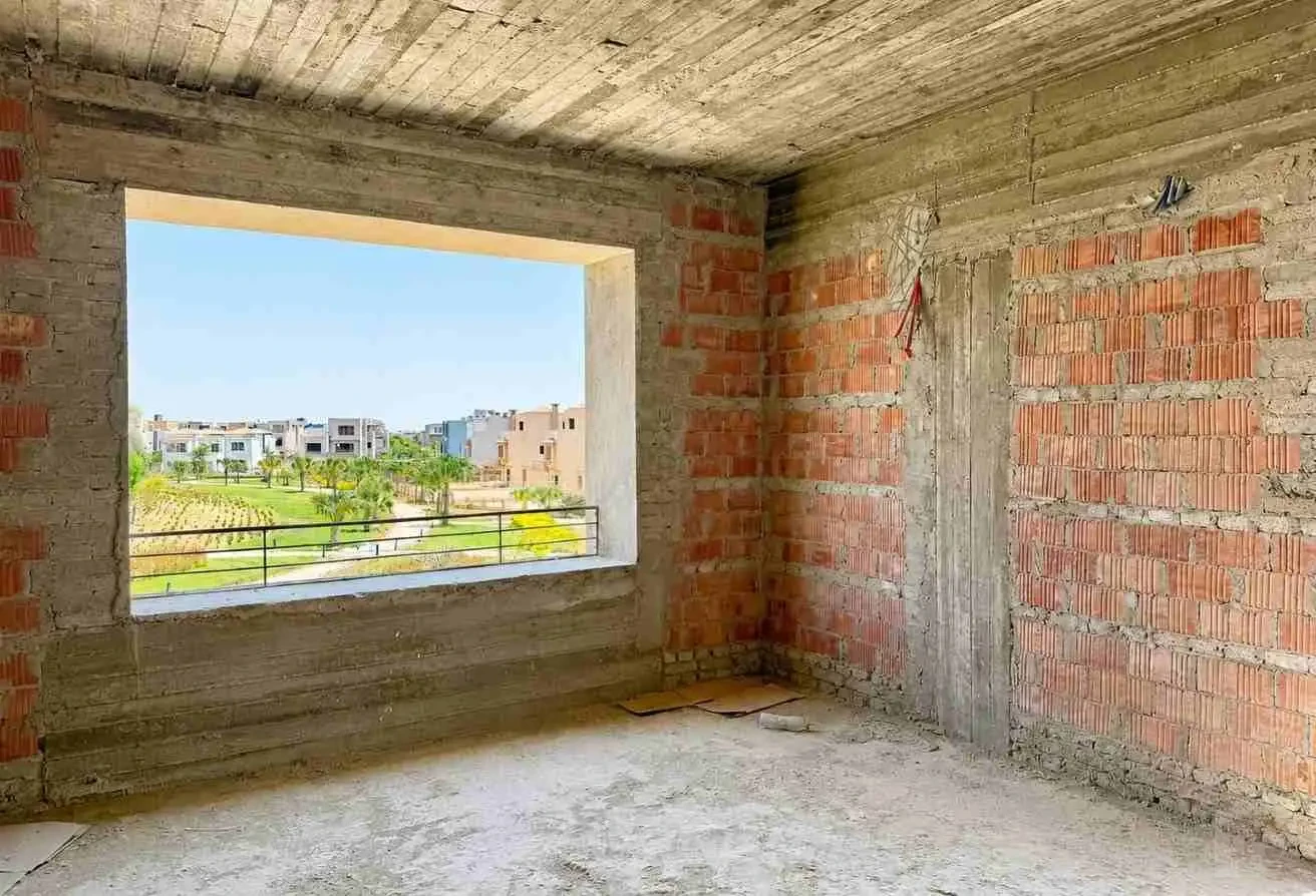 مساحة غرفة داخلية أخرى تحت الإنشاء (مرحلة الطوب) مع نافذة كبيرة